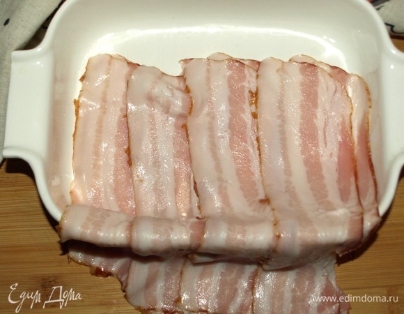 Полоски бекона кладем в форму для запекания так, чтобы они свисали с бортика. Форму лучше взять небольшую.