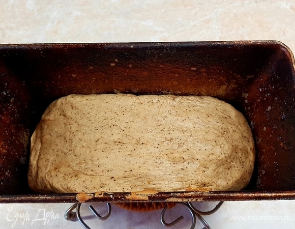 Форму для выпечки хлеба смазать маслом и выложить в нее тесто. Оставить на 20 минут. Потом поставить в духовку, разогретую до 240°C, и выпекать 10 минут. После этого снизить температуру до 200°C и выпекать еще 25 минут.