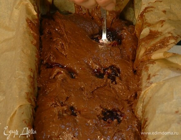 Форму для кекса выстелить бумагой для выпечки, выложить тесто и разровнять его, сверху в тесто чайной ложкой добавить вишневый джем.