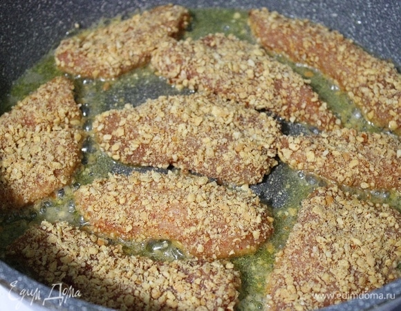 На сковороду добавляем растопленное сливочное масло. Курицу обмакиваем в измельченном арахисе и обжариваем до готовности.