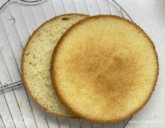 Остудить бисквит. Разрезать на 2 части.