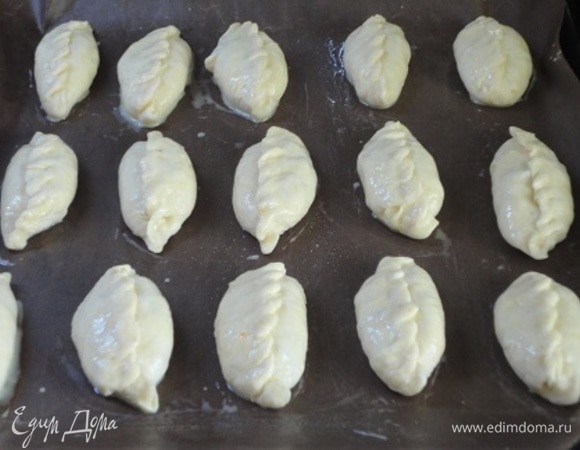 Тесто разделите на 16 кусочков, каждый раскатайте в лепешечку, выложите начинку и сформируйте пирожки. Смажьте яйцом.