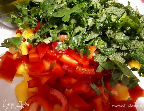 Нарежьте перец кубиками. Порубите зелень и добавьте к манго.