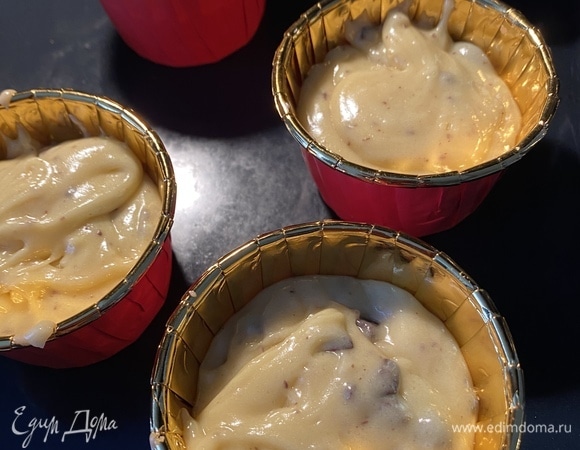 Духовку разогреть до 170°C. Выложить тесто в формочки для кексов (наполняйте чуть больше, чем на 1/2).