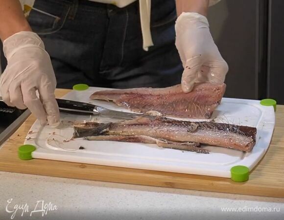 Замаринованную сельдь разделить на филе, удалив кожу и кости, затем нарезать кусочками.
