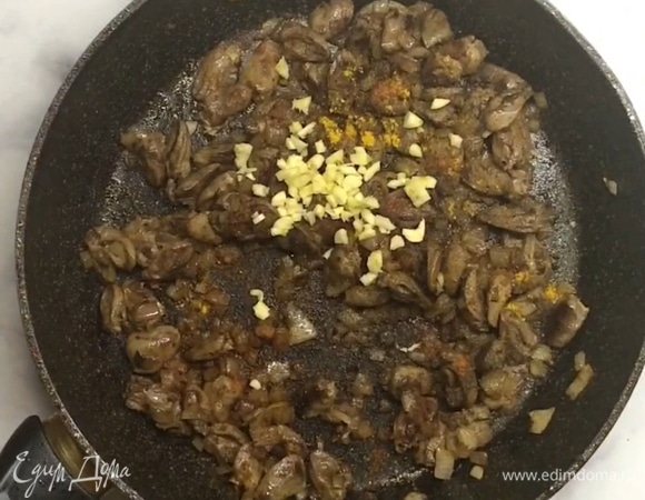 Затем выключаем огонь и добавляем к сердечкам соевый соус, мелко нарезанный чеснок, черный и красный перец, молотый кориандр или куркуму, нарезанный зеленый лук.