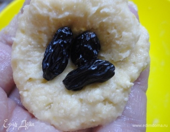 От готового теста отщипываем кусочек величиной с грецкий орех, руками формируем лепешечку, выкладываем в нее по 3 изюминки и собираем в шарик, который обмакиваем (по желанию) в сахаре с корицей или ванильном сахаре.