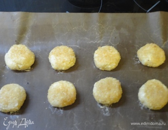 Выкладываем на противень и слегка прижимаем сухой чайной ложкой.