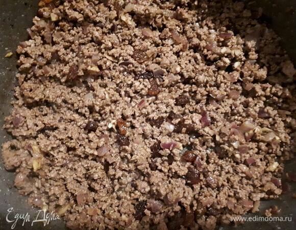 Затем добавьте фарш и обжарьте до готовности. Всыпьте изюм и кедровые орешки и перемешайте.