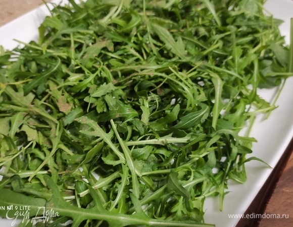 За это время подготовить руколу, разложить на большое блюдо и поперчить.