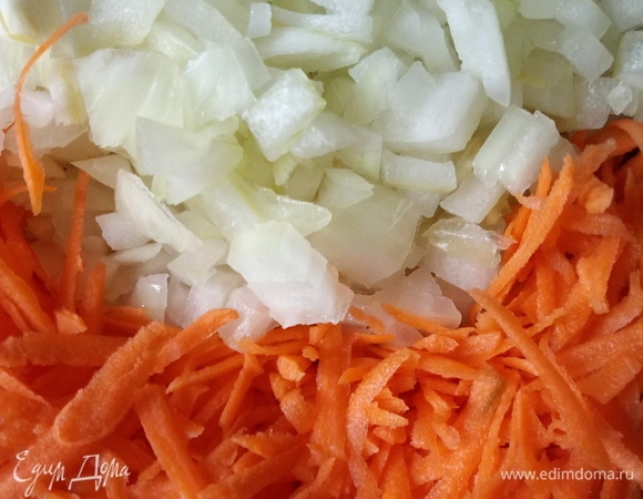 Лук мелко нарезать, морковь натереть на мелкой терке. Достать рыбу из бульона. Бульон процедить. Лук и морковь положить в процеженный бульон и варить в кипящей воде 5 мин.