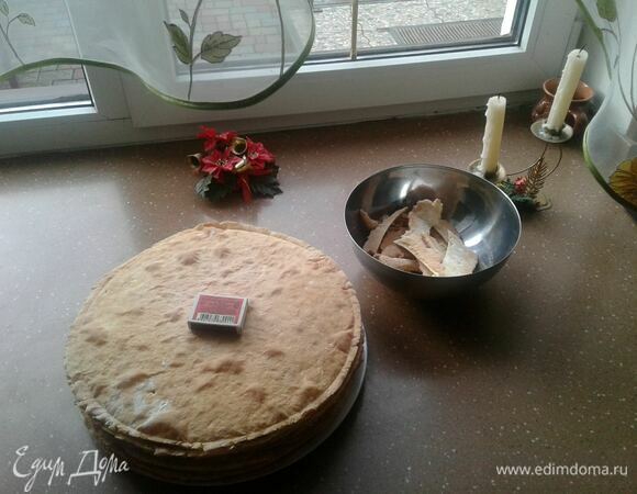 Выпекать коржи на припыленном мукой протвине при 180–200°C по 4–5 мин, до розового цвета. Выложить на деревянную доску и сразу обрезать. У меня была крышка диаметром 30 см. Обрезки пригодятся для посыпки.