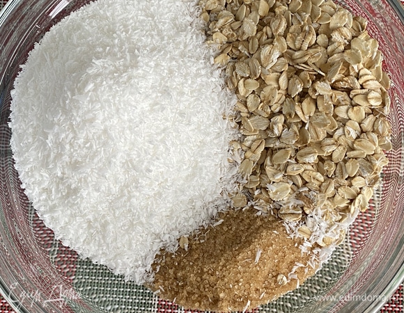 Смешать в глубокой миске сахар, кокосовую стружку, хлопья и муку, перемешать венчиком до однородности. Хлопья лучше измельчить блендером, но не до состояния муки.