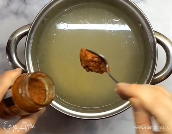 Уменьшаем огонь, добавляем пасту «Том Ям» и варим еще 5 минут.