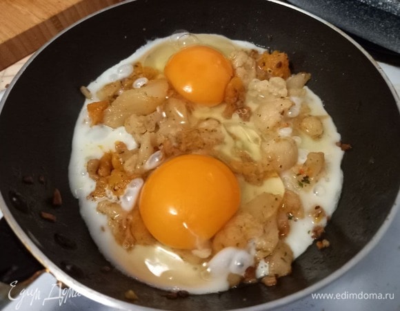 Аккуратно разбиваем два яйца поверх овощей, стараясь не повредить желток, в таком виде яичница-глазунья будет еще симпатичнее. Накрываем крышкой, чтобы белок лучше схватился, на 1–2 минуты, но желток при этом должен оставаться сырым.