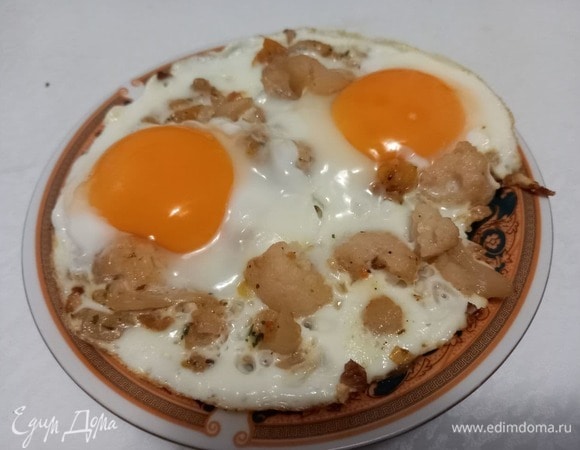 Поддевая яичницу лопаткой с краев, аккуратно, стараясь не повредить желток, перекладываем яичницу на тарелку.