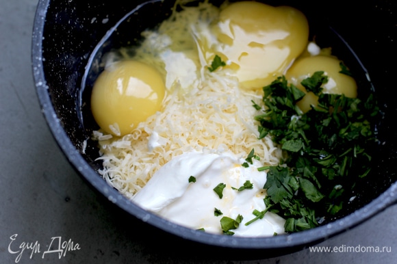 Яйца взбейте со сметаной, добавьте 3–4 ст. л. воды, соль, перец, натертый сыр, мускатный орех и резаную зелень.