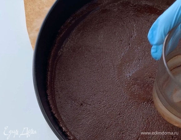 Утрамбуйте равномерно шоколадную основу сначала ложкой, а затем стаканом с плоским дном сделайте небольшие бортики. Поставьте шоколадную основу в холодильник на 25–30 минут.