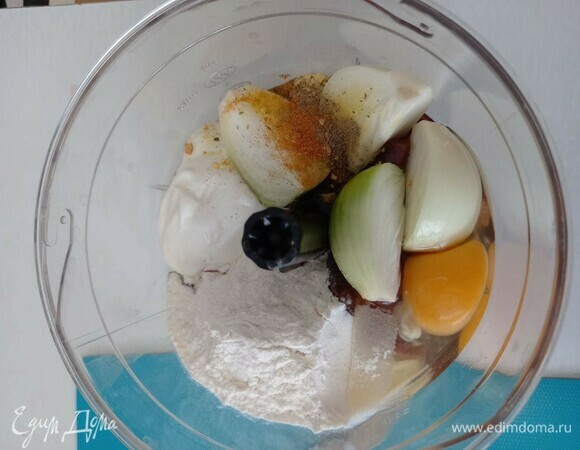 В чашу блендера сложить все ингредиенты для коржей, кроме масла: нарезанную на куски печень, разрезанную на четыре части луковицу, одно куриное яйцо, примерно 2 ст. л. муки и столько же сметаны, молоко и специи: соль, черный и красный перец. Специи можно использовать любые.