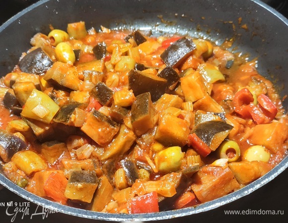 Выложить баклажаны к остальным овощам, добавить томат и пассату, изюм, каперсы и оливки. Добавить уксус, сахар и 150 мл воды. Тушить примерно 25 минут. Посолить. Помешивать, чтобы не пригорело.