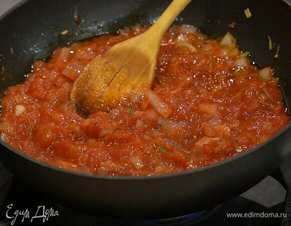Когда лук станет прозрачным, ввести томатную пасту, перемешать и немного прогреть, затем добавить консервированные помидоры и еще немного прогреть, палочку корицы удалить.
