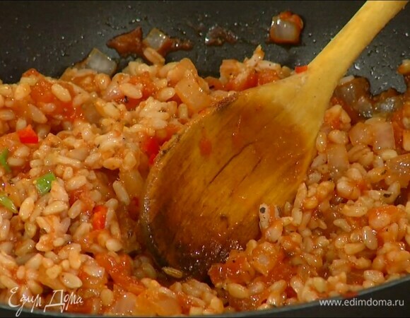 Рис отварить до полуготовности и выложить в сковороду с томатной массой, добавить чили, измельченную зелень, все поперчить и перемешать.