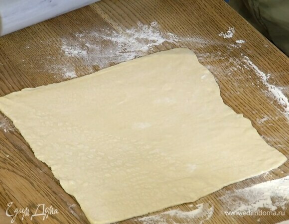 Слоеное тесто предварительно разморозить, затем раскатать на слегка присыпанной мукой рабочей поверхности в тонкие пласты.