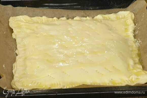Накрыть пирог третьим пластом теста, скрепить края и прижать их вилкой, сверху часто наколоть тесто вилкой и смазать оставшимся растопленным маслом.