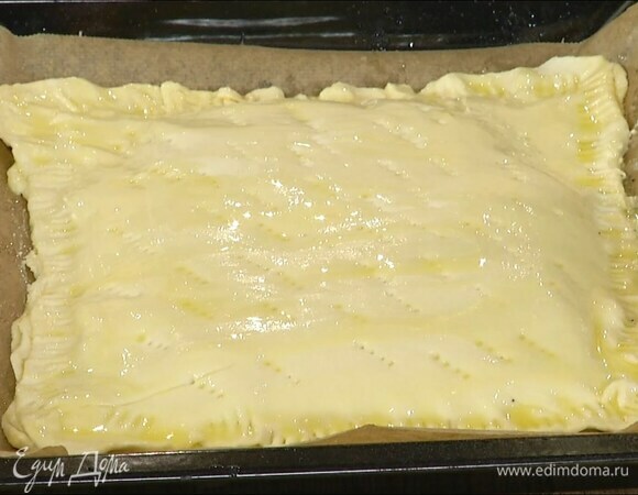 Накрыть пирог третьим пластом теста, скрепить края и прижать их вилкой, сверху часто наколоть тесто вилкой и смазать оставшимся растопленным маслом.