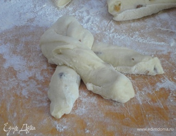 Разделить на 8–10 частей по 140–150 г. Разрезать на три полоски, оставляя один конец целым, и заплести косичку.