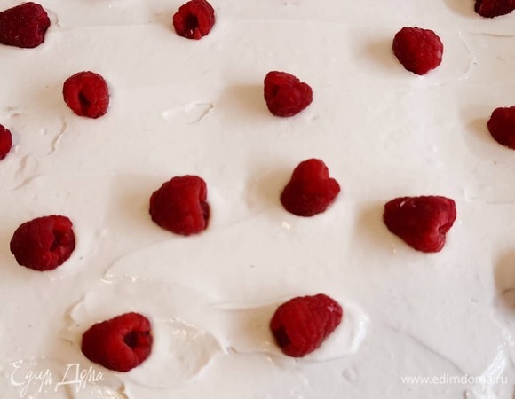 Смазать кремом всю поверхность бисквита, разложить ягоды.