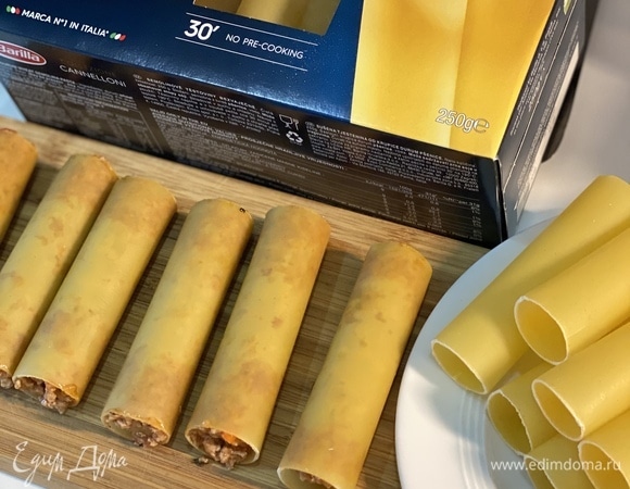 Остудить начинку, переложить в кондитерский мешок или плотный пакет и начинить сырые каннеллони.