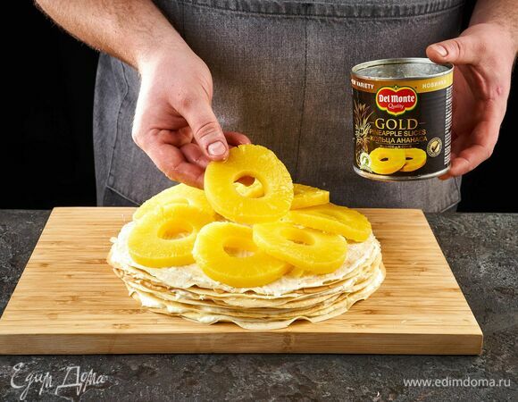 Самый верхний слой тоже смажьте кремом и выложите кольцами ананаса Del Monte Gold.