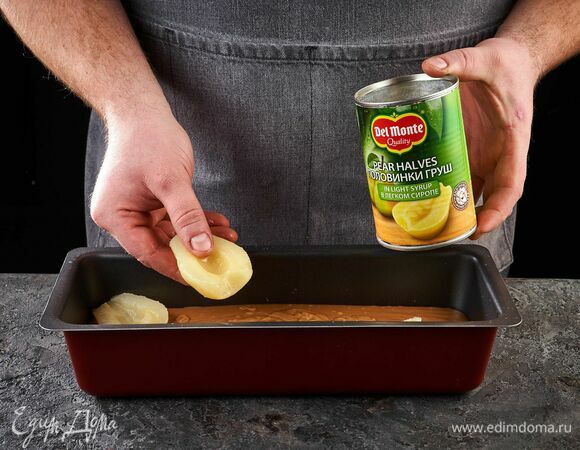Выложите половинки груш в легком сиропе Del Monte, слегка утопите в тесто. Выпекайте кекс в разогретой духовке при 170°С около 40 минут.