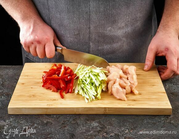 Сладкий перец и лук-порей нарежьте соломкой. Куриное филе нарежьте на средние кусочки.