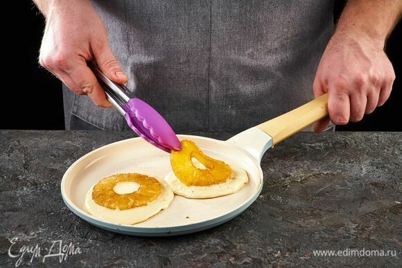 На чистую сковороду выложите тесто для панкейка, сверху положите обжаренные кольца ананаса. Когда тесто покроется пузырьками и схватится по краям, осторожно переверните панкейк лопаткой. Повторите с остальным тестом.