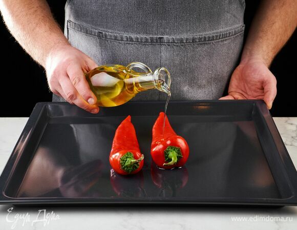 Перцы выложите на противень, полейте оливковым маслом и запекайте 15 минут в духовке, разогретой до 200°C. <br />
С запеченных перцев снимите кожуру.