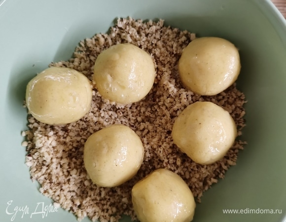 Обмакнуть каждый в яичном белке. Обвалять шарики в орехах.