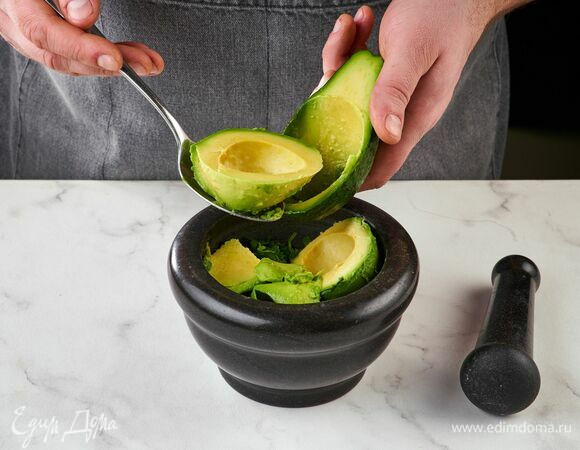 Переложите авокадо, чили, чеснок и кинзу в ступку.