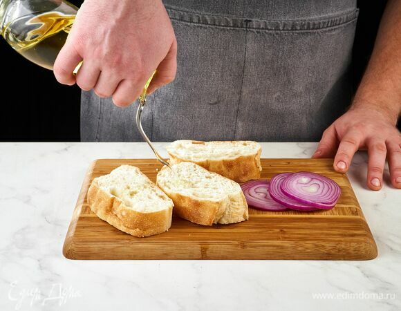 Чиабатту нарежьте ломтиками толщиной не менее 1,5 см. Сбрызните оливковым маслом. Красный лук нарежьте кольцами.