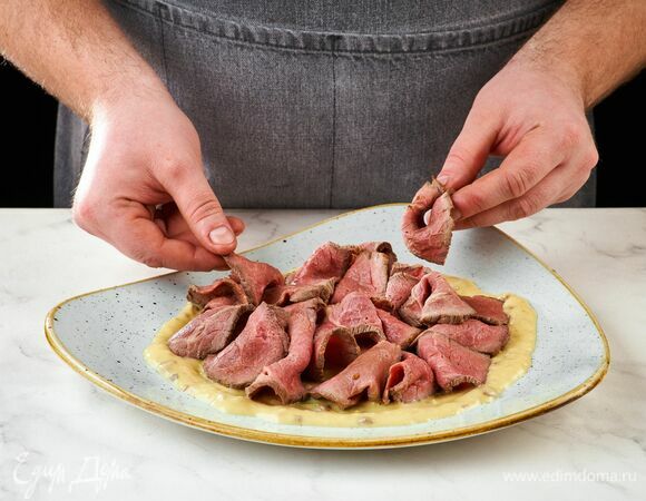 Готовое мясо остудите, тонко нарежьте. В тарелку налейте соус, выложите мясо.