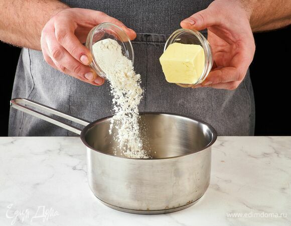 Приготовьте белый соус. Муку и масло добавьте в сотейник, грейте на огне, пока масло не растопится, перемешайте.