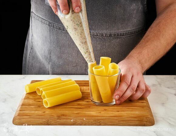 При помощи кондитерского мешка наполните каннеллони мясной начинкой.