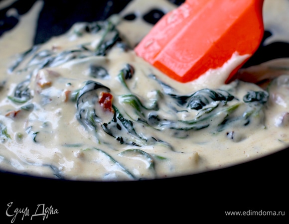 Духовку разогрейте до 210°C, запекайте рыбу 15–17 минут. Промойте шпинат, отрежьте ножки у корня, обсушите. В сковороде разогрейте масло с чесноком. Как только оно начнет шипеть, добавьте шпинат и, помешивая, тушите до увядшего состояния. Добавьте сливки, приправьте солью и перцем и доведите соус до кипения. Проварите минуту, добавьте нарезанные вяленые помидоры.