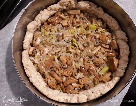 Смажьте дно тарта горчицей и выложите лисички.