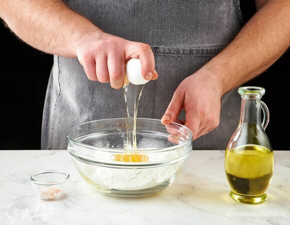 Приготовьте тесто для равиоли. В глубокой чаше соедините муку, яйцо, оливковое масло и соль. 