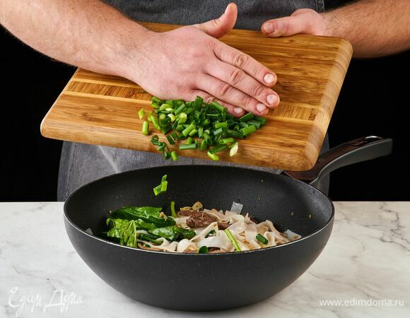 Нарежьте зеленый лук, добавьте в сковороду. Перемешайте.