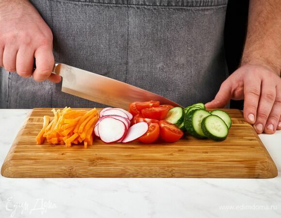 Морковь нарежьте тонкой соломкой, помидоры черри — пополам, редис — тонкими слайсами, огурец — кружочками.