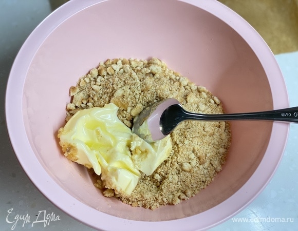 Печенье измельчить любым удобным способом до крошки. Масло растопить и смешать с крошкой. Выложить в подготовленную форму диаметром 22–24 см и утрамбовать.