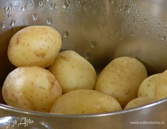 Вскипятить воду в кастрюле, опустить в нее вымытый картофель и отваривать целиком 10 минут, затем разрезать пополам.